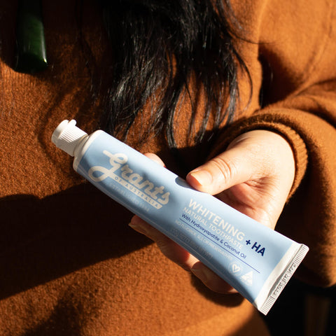 Hand holding a tube of Grants whitening toothpaste