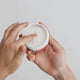 Amazing You Fix My Face Magnesium Moisturiser 100g lifestyle close up of two hands holding the open tub and scooping out cream