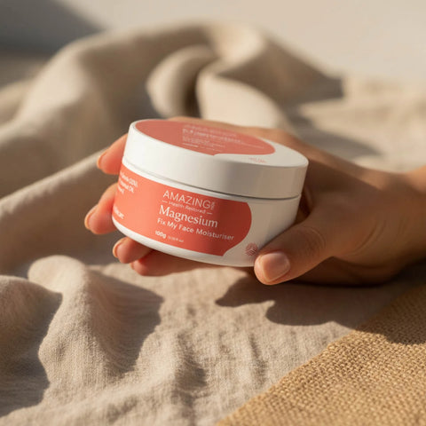 Amazing You Fix My Face Magnesium Moisturiser 100g lifestyle shot of a hand holding the tub on soft sand coloured fabric, close up of the tub