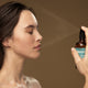 Model spraying ultra-hydrating mist on her face.