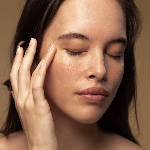 Model applying eye gel to her under eye area.