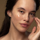 Model applying baptise hydrating gel to her cheeks.