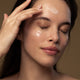 Model applying culture probiotic night recovery cream to her face.
