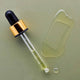 Dropper with gold cap and black top on a green background with a small droplet and swatch of eve bio retinol line reduction serum.