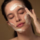 Model applying antipodes grace gentle cream cleanser to her face.