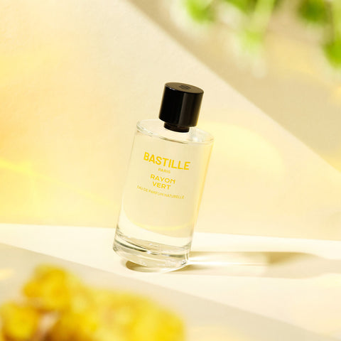 100ml bottle Bastille Rayon Vert Perfume, natural vegan perfume styled with a yellow background.