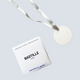 Bastille Perfume Ceramic freebie, a white ceramic tablet on a silver ribbon with a small Bastille box, on a pale blue backdrop