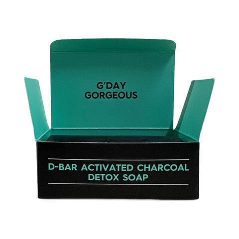Black Chicken Remedies D-Bar Activated Charcoal Detox Soap 100g open black box with a green interior and the soap beside it on white