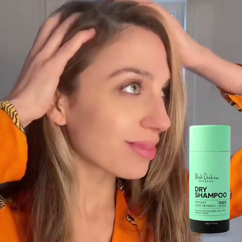 Black Chicken Remedies Dry Shampoo lifestyle shot of a woman with long light brown hair running her fingers through it, the green stick in the corner