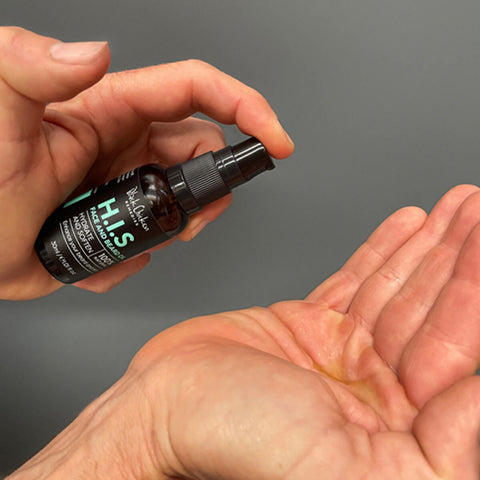 Black Chicken Remedies H.I.S Face & Beard Oil 30ml lifestyle shot of a hand pumping the oil from the dark bottle onto an open palm