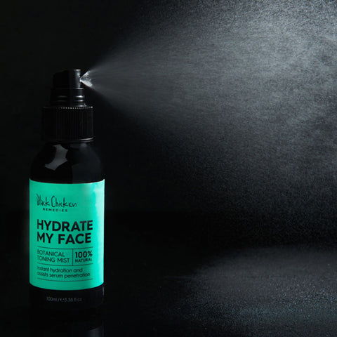Black Chicken Remedies Hydrate My Face Toning Mist lifestyle shot of the bottle spraying a fine mist against a dark backdrop, styled lifestyle photo