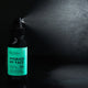Black Chicken Remedies Hydrate My Face Toning Mist lifestyle shot of the bottle spraying a fine mist against a dark backdrop, styled lifestyle photo