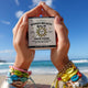 Person holding a 'Bondi Beach Balm' product with a beach in the background