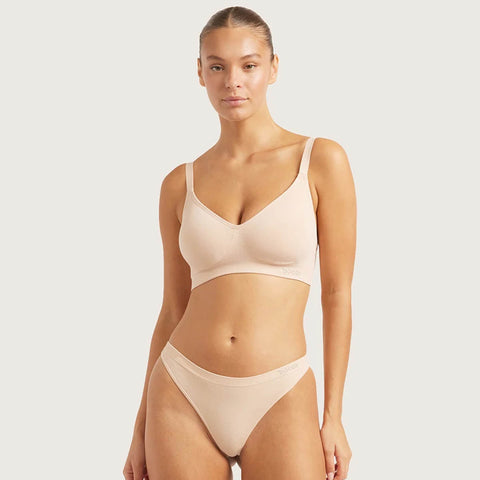 Boody G-String Shell lifestyle shot of a woman with her hair up in a nude bra and the nude g-string, front view, styled lifestyle photo