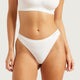 Boody G-String White lifestyle close up of a person's hips and torso wearing the white g-string, front view, styled lifestyle photo