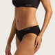 Boody Hipster Bikini Black lifestyle close up of a woman's torso from the side wearing the briefs with the Boody logo waistband