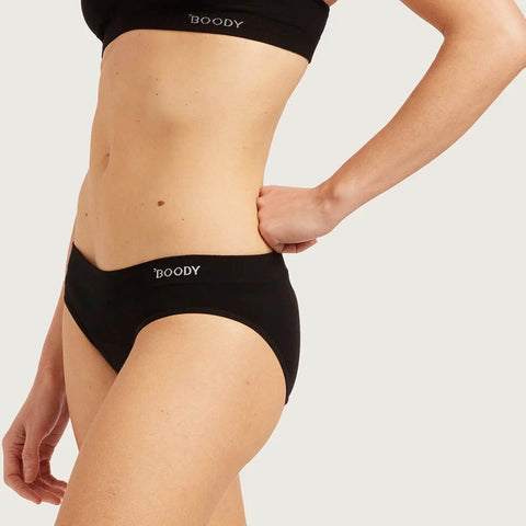 Boody Period & Leak Proof Classic Bikini Moderate-Heavy in black, close-up of the front waistband and bikini on a model's torso and hip