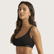 Boody Seamfree Crop Bra Black lifestyle shot of a woman with long dark hair turned side on in the black bra, styled lifestyle photo