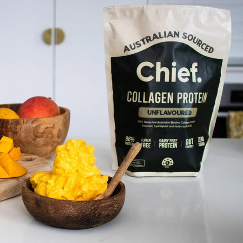 Bag of Australian Sourced Chief Collagen Protein with a bowl of fruits on a white surface.