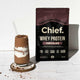 Chocolate protein shake with a package of Chief Whey Protein Chocolate on a white background