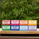 Assorted Magic Bar Soaps on a wooden surface with a green leafy background