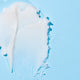 Dr Zoo Nose & Paw Butter swatch showing thick white texture on a light blue background.