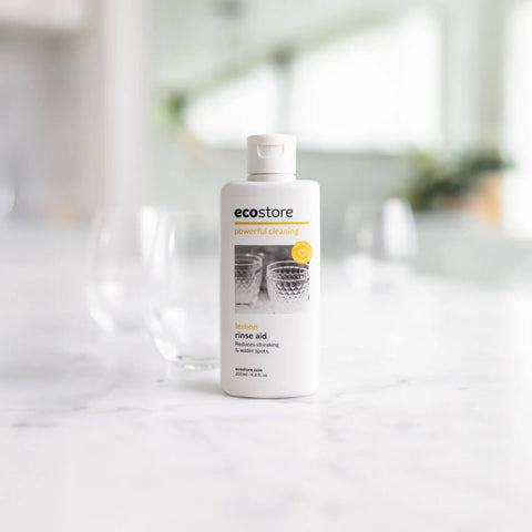 Bottle of ecostore Rinse Aid on a white marbled surface.