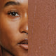 Model next to swatch of Elate Beauty Creme Concealer in the shade 'CW6', for medium deep warm skin tones. A two-in-one concealer and illuminator formulated with evening primrose oil, designed to heal and conceal blemishes.