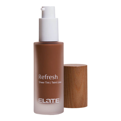 Elate Beauty Refresh Foundation 30ml RW8 in a frosted glass bottle with a white pump and a wooden cap beside it, showing a dark brown tint on white