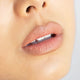 Ere Perez Acai Lip Pencil Pout lifestyle close up of a woman's lips in a soft peach nude shade, face cropped, styled lifestyle photo