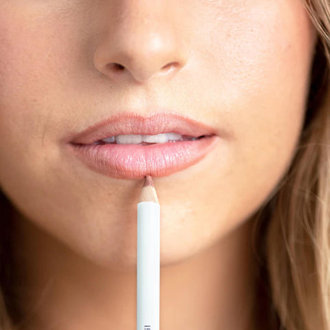 Ere Perez Acai Lip Pencil Shy lifestyle close up of a woman's lips in a light pink shade as a white pencil traces the lip line