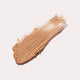 Ere Perez Arnica All-Cover Pot Brew swatch, a streak of warm caramel concealer, close up of the texture, clear product photo, single image