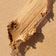 Ere Perez Arnica All-Cover Pot Caramel swatch, a streak of golden crumbly concealer, close up of the texture, clear product photo