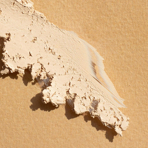 Ere Perez Arnica All-Cover Pot Latte swatch, a streak of pale cream crumbly concealer, close up of the texture, clear product photo