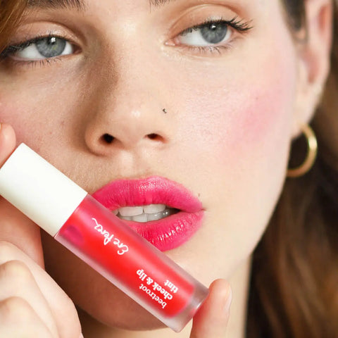 Close-up of a woman's face with 'Fun' pink lip tint applied to her cheeks & lips. 