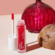 Red lip tint with applicator and beetroot in the background on a neutral surface