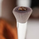 Ere Perez Eco Vegan Brush Multipurpose close up of the soft bristle head with a dab of foundation on the tip, clear product photo