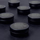 Multiple containers of 'essential dog' natural nose and paw balm on a dark surface.