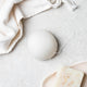 Original konjac sponge pictured on a bathroom surface next to a face towel.