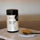 100g jar Evolution Botanicals Himalayan Shilajit and powder on a counter.
