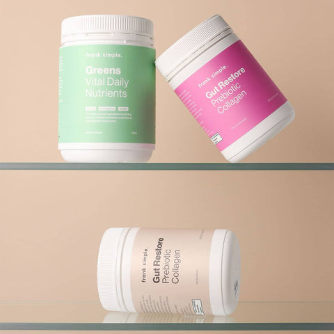 Three supplements from Frank Simple the Frank containers on a glass shelf against a beige background.