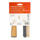 A plastic brush in its retail packaging, featuring a natural bamboo handle, a dark gray plastic base, and natural bristles. The backing card is orange and white with text and icons related to plastic reduction and care instructions.