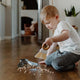 Child sweeping spilled cereal with the tiny team mini brush & dustpan.