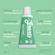 Green travel-size tube of Grants toothpaste on a green background with text highlighting its benefits.