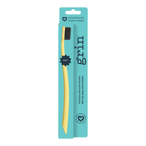 Grin 100% Recycled Charcoal-Infused Toothbrush Soft in lemon yellow on a teal card pack, front view on a plain white background