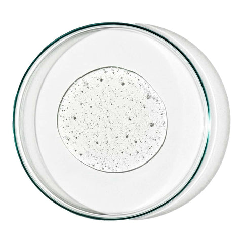 Grown Alchemist Revitalize Hand Wash swatch, a clear gel with tiny bubbles in a glass petri dish, overhead on a plain white background