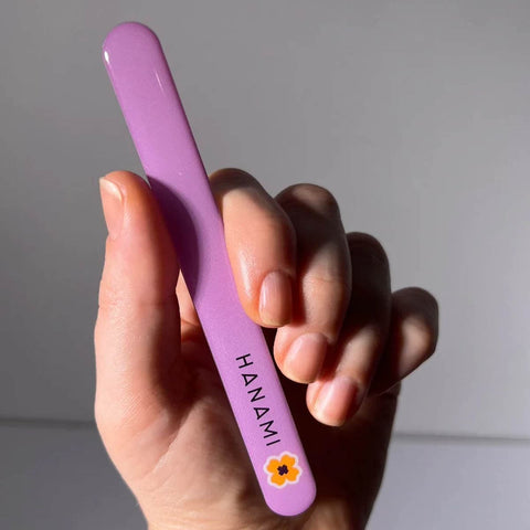 Hand holding a purple tool with 'HANAMI' branding against a neutral background.