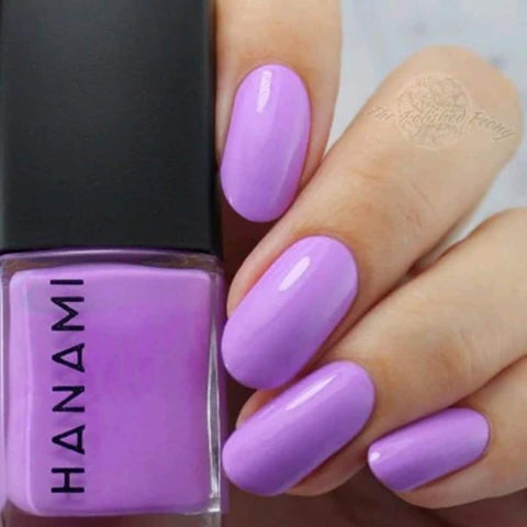 Purple nail polish bottle with a hand showing nails painted with the same colour.