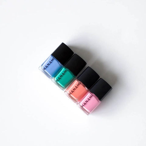 Four bottles of Manam nail polish in blue, green, pink, and red on a white background.