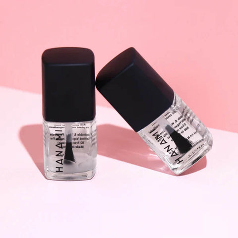 Two nail polish bottles with black caps on a pink background